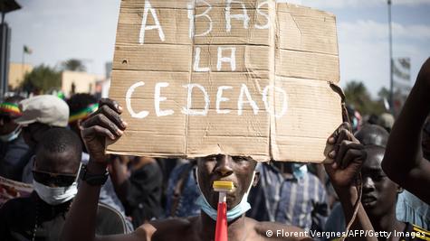 Un manifestant tenant une pancarte avec l'inscription "A bas la Cédéao"