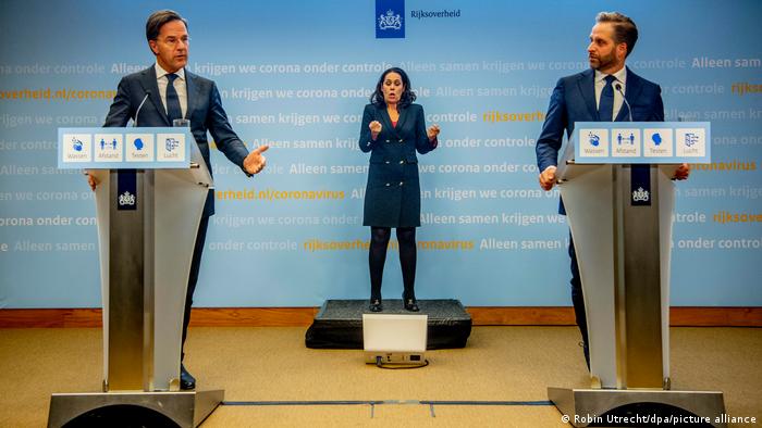 Prime Minister Mark Rutte (left), sign interpreter Irma Sluis (center) and former Health Minister Hugo de Jonge outline COVID measures in the Netherlands