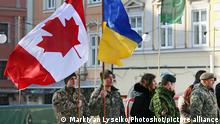Servicemen hold the flags of Ukraine (R) and Canada at the start of a match between Canadian servicemen engaged in the Operation UNIFIER (red kit) and players of HC Halytski Levy on the Ice Hockey Day, Lviv, western Ukraine, February 10, 2019. Ukrinform.