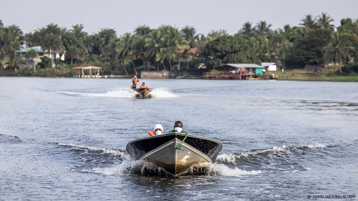 Animal welfare workers in boats, bringing food to the apes on the islands, November 2021, (Photo by JOHN WESSELS / AFP)