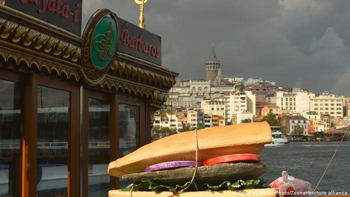 A large model of a Balik ekmek fish sandwich next to the water