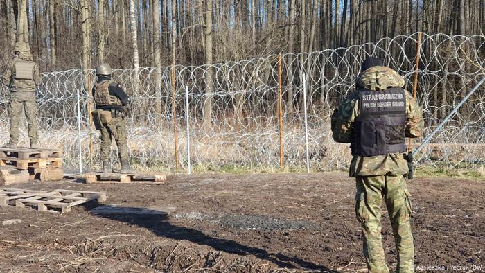 Border guards near a razor wire fence