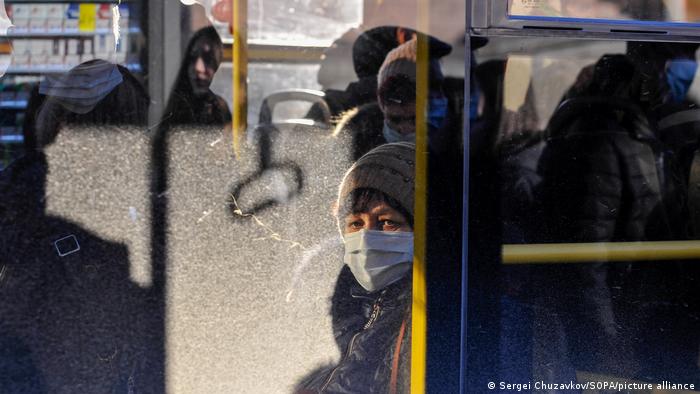 A woman wearing a face mask rides a bus in Kyiv during the coronavirus crisis