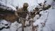 Ukrainian soldier with rifle walking through a trench in the snow Ukrainian soldier with rifle walking through a trench in the snow