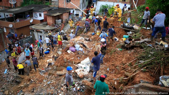 Firefighters and residents search for victims near houses destroyed by a landslide in Franco da Rocha