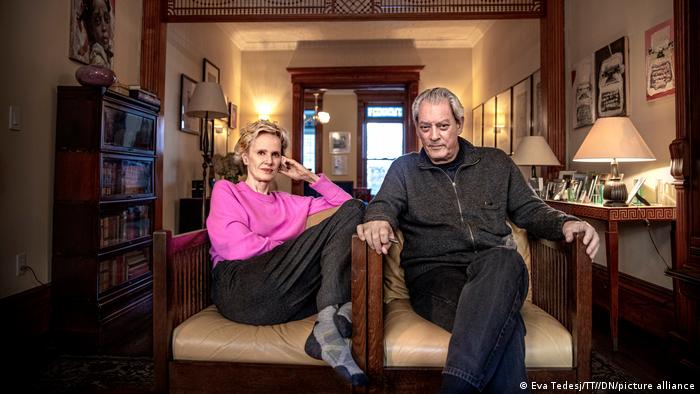 Siri Hustvedt und Paul Auster sitzen in Sesseln nebeneinander in ihrem Wohnzimmer.