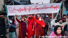 Youth activists and Buddhist monks participate in an anti-military government protest rally while holding a banner that reads in Burmese, Who dares to stay on the opposite side of the people's will, on Tuesday, Feb. 1, 2022, in Mandalay, Myanmar. The new U.N. special envoy for Myanmar says violence has intensified since the military took power a year ago and sparked a resistance movement in the country. (AP Photo)