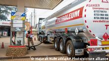 A transporter truck delivers fuel to a Total gas station in the Kamwokya suburb of Kampala, Uganda, Tuesday, Feb. 1, 2022. Uganda and a group of investors on Tuesday announced their decision to finally proceed with oil production following years of setbacks that threatened the East African country's efforts to become an oil exporter. (AP Photo/Hajarah Nalwadda)