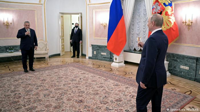 Premijer Mađarske Viktor Orban na jednom kraju sobe i ruski predsjednik Vladimir Putin na drugom nazdravljaju jedan drugom