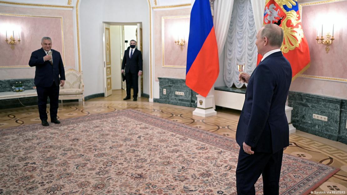 Russian President Vladimir Putin (right) and Hungarian Prime Minister Viktor Orban (left) hold glasses while standing at a distance to each other during a meeting in Moscow, February 1, 2022