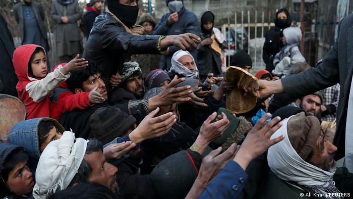 People reach out to receive bread in Kabul, Afghanistan