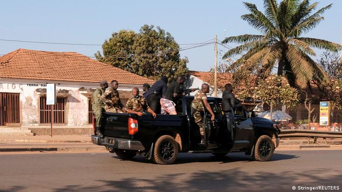 Armed soldiers move on the main artery of the capital after heavy gunfire around the presidential palace in Bissau