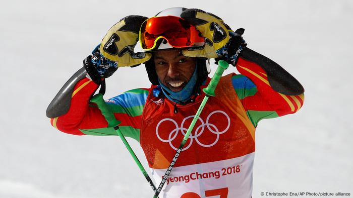 Skiier Shannon Abeda from Eritrea lifts his ski goggles at the Winter Olympic Games in Pyeongchang and smiles 