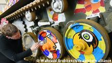 Der Leipziger Künstler Michael Fischer-Art bemalt in seinem Atelier in einer früheren Brikettfabrik bei Leipzig einen alten britischen Luftlandepanzer in den Farben der Fahnen von Russland (l) und der Ukraine und fröhlichen Motiven. Der Pop-Art Künstler will mit seinem Kunstwerk Frühlingspanzer für Verständigung und einem Miteinander zwischen den Ländern werben. Der Panzer, den er von einem Schrotthändler in der Eifel erstanden hat, soll seine Aktion in drei Wochen begleiten. Mit Künstlerkollegen aus der Ukraine und Russland will er an der Grenze zwischen beiden Ländern für ein friedliches Miteinander demonstrieren. +++ dpa-Bildfunk +++