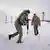Dois soldados andando em paisagem nevada