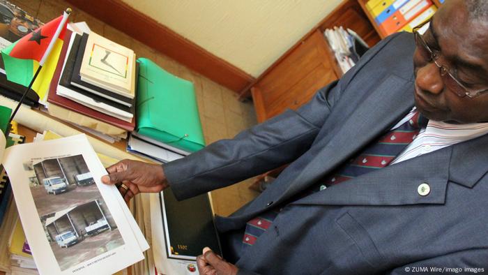 Then-Interpol chief Calvario Ahukharie shows photos in 2012 of soldiers unloading a shipment of cocaine