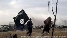 ARCHIV - 19.03.2019, Syrien, Baghus: IS-Kämpfer laufen mit einer IS-Flagge. Das US-Militär hat nach Angaben des Weißen Hauses bei einem Einsatz im Nordwesten Syriens den Anführer der Terrormiliz Islamischer Staat (IS) getötet. Er habe den Einsatz in der vergangenen Nacht gegen Abu Ibrahim al-Haschimi al-Kuraschi angeordnet, erklärte US-Präsident Biden am Donnerstag. Foto: Amaq News Agency/AP/dpa +++ dpa-Bildfunk +++