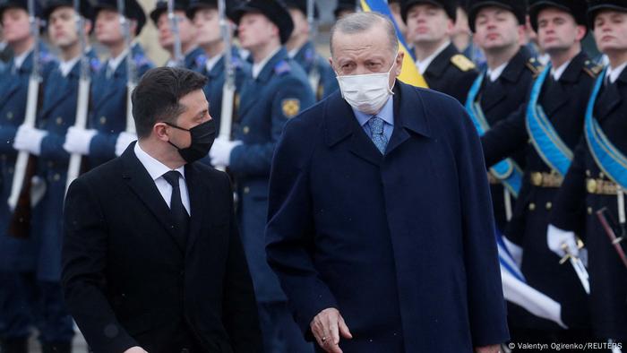 Le président ukrainien Volodymyr Zelenskyy (à gauche) et le président turc Recept Tayyip Erdogan (à droite), tous deux masqués, devant un défilé de bienvenue de soldats à Kiev, le 3 février 2022