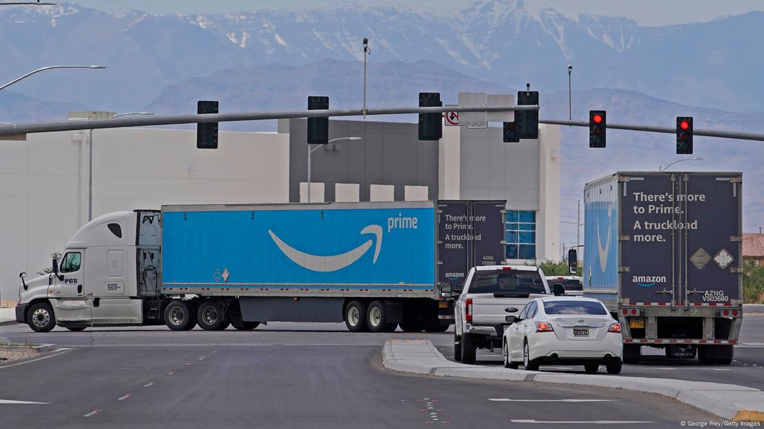 Two trucks display the Amazon Prime logo as they leave a distribution center in Las Vegas, Nevada