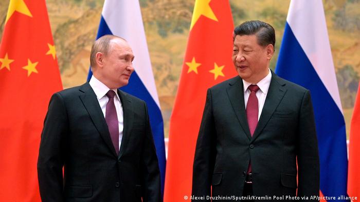 China | Wladimir Putin und Xi Jinping vor den beiden Nationalflaggen