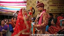 An Indian couple performs marriage rituals during a mass marriage for eight couples in New Delhi, India, Friday, March 8, 2019. Mass weddings in India are organized by social organizations primarily to help economically backward families who cannot afford the high ceremony costs as well as the customary dowry and expensive gifts that are still prevalent in many communities. (AP Photo/Altaf Qadri)