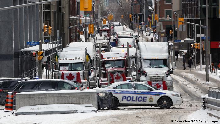 Trucks blocking a street in Ottawa with police car in front
