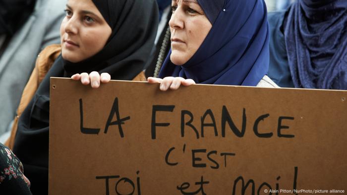 French women hold up a sign against Islamophobia at a protest in Toulouse