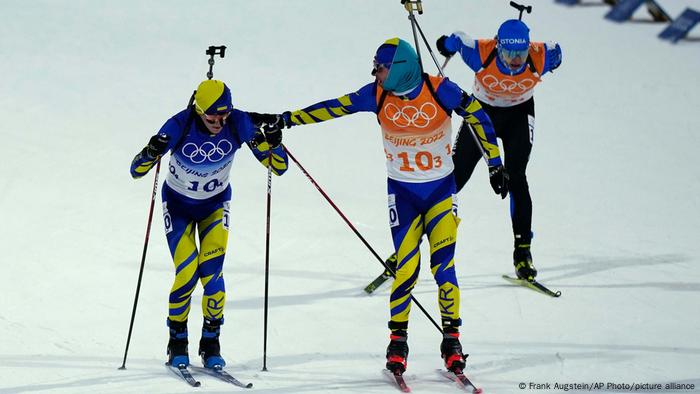 Український біатлоніст Артем Прима (праворуч) приймає естафету у Дмитра Підручного під час змішаних перегонів на зимовій Олімпіаді у Пекіні