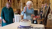 Königin Elizabeth II. (M) schneidet während eines Empfangs im Ballsaal von Sandringham House, der Residenz der Königin in Norfolk, eine Torte an, um den Beginn des Platin-Jubiläums zu feiern. Die Queen begeht am Sonntag ihr 70-jähriges Thronjubiläum. +++ dpa-Bildfunk +++