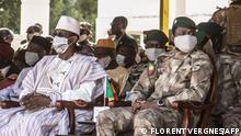 Malian Prime Minister Choguel Kokalla Maïga (C-L) and transitional Malian President Assimi Goita (C-R) wait for the militia parade during the ceremony celebrating the army's national day, in Kati, on January 20, 2022. - With the support of French, European and Russian partners, the Malian army is trying to regain the territories occupied by armed groups and jihadists. (Photo by FLORENT VERGNES / AFP)