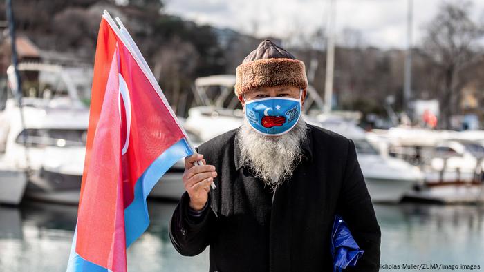 February 4, 2022, Istanbul, Turkey: A protester holding flags and wearing a fancy face mask, during the demonstration..
