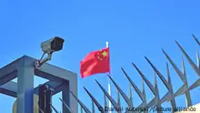 Symbolbild China Kamera am Zaun des Chinesischen Generalkonsulats in Frankfurt am Main, im Hintergrund weht die Flagge der Volksrepublik China.