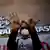 Imagem foca mãos estendidas de pessoa usando máscara diante da sede do Banco Central, em Brasília. Nas palmas, está escrito "Fome". A pessoa participa de um protesto contra propostas econômicas do governo de Jair Bolsonaro (PL), em janeiro de 2022.