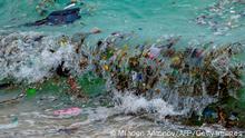 TOPSHOT - A wave carrying plastic waste and other rubbish washes up on a beach in Koh Samui in the Gulf of Thailand on January 19, 2021. (Photo by Mladen ANTONOV / AFP) (Photo by MLADEN ANTONOV/AFP via Getty Images)