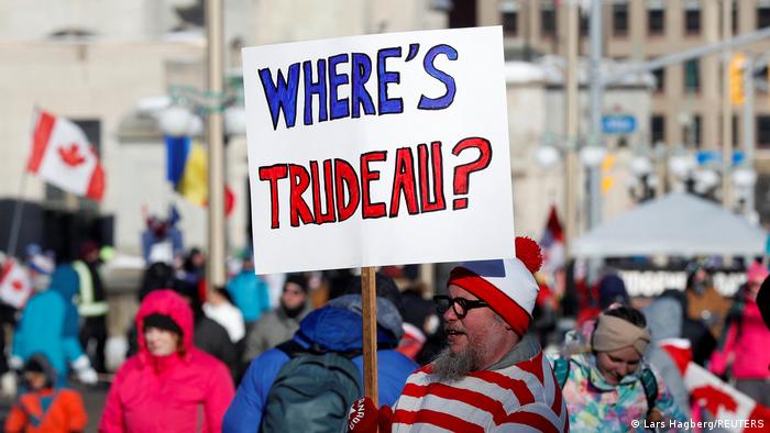 Protester holding sign that says, 'Where is Trudeau?'