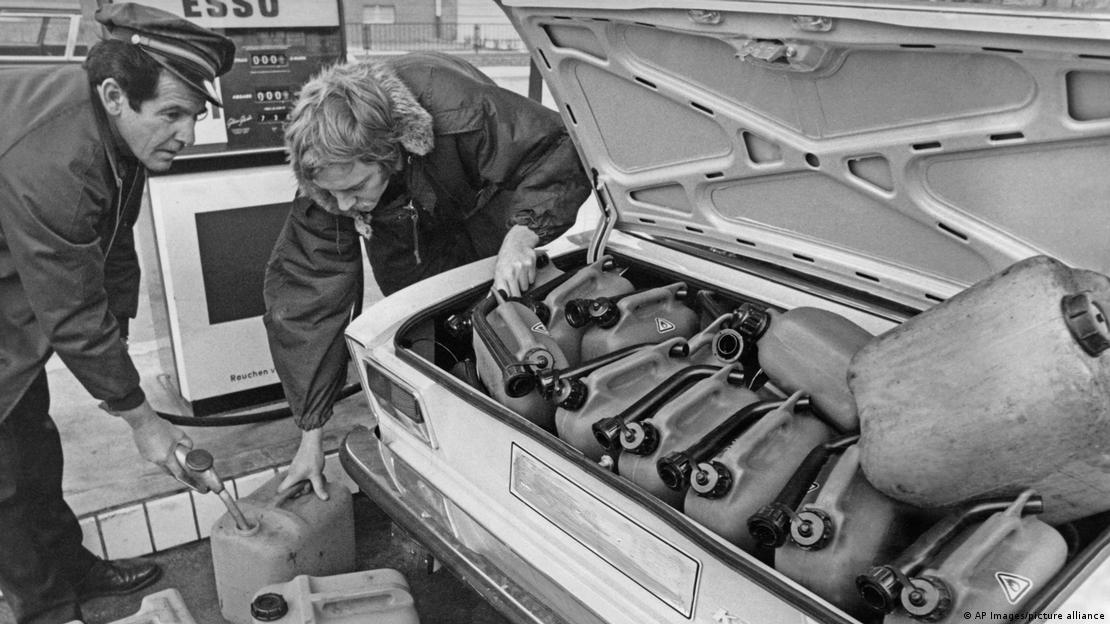 Crisis del petróleo de 1973: dos hombres cargan gasolina en bidones de plástico.