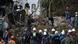 Rescue workers and a dog search for victims in the rubble and mud Rescue workers and a dog search for victims in the rubble and mud