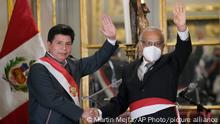 Peru's President Pedro Castillo, left, waves alongside his new Cabinet Chief Anibal Torres, during the swearing-in of Castillos´s new Cabinet, at the government palace in Lima, Peru, Tuesday, Feb. 8, 2022. This is Castillo's fourth Cabinet shakeup in six months. (AP Photo/Martin Mejia)