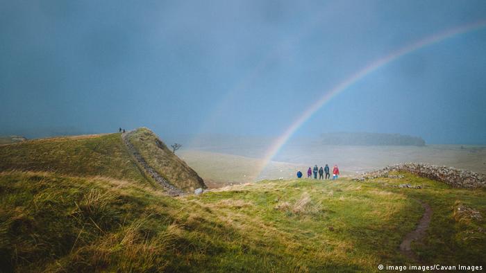 Tourists on Hadrian's Wall enjoying a double rainbow over the listed site.