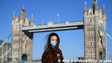 LONDON, ENGLAND - MARCH 22: A member of the public poses for a photo in front of Tower Bridge whilst wearing a protective mask on March 22, 2020 in London, England. Coronavirus (COVID-19) has spread to at least 188 countries, claiming over 13,000 lives and infecting more than 300,000 people. There have now been 5,018 diagnosed cases in the UK and 233 deaths. (Photo by Alex Davidson/Getty Images)
