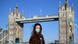 Eine Frau mit Maske vor der Tower Bridge in London Eine Frau mit Maske vor der Tower Bridge in London