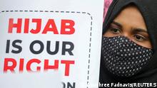 A Muslim student holds a placard during a protest by Muslim Students Federation (MSF) against the recent hijab ban in few of Karnataka’s colleges, in New Delhi, India, February 8, 2022. REUTERS/Anushree Fadnavis