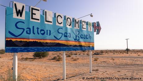A signpost once welcoming tourists to the shores of Salton Sea now standing in the middle of the sourrounding desert