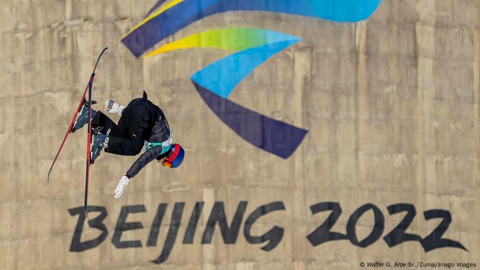 Eileen Gu performs a trick in front of a Beijing 2022 logo