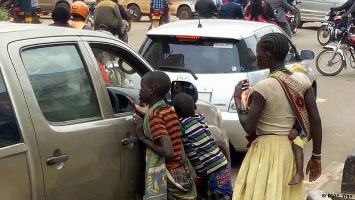 Street children begging a motorist.