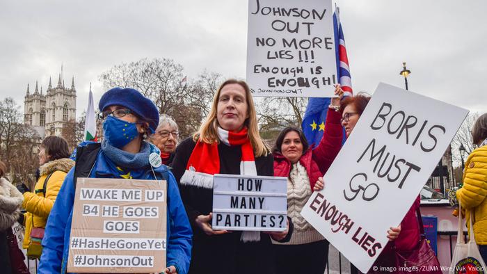 Demonstrators hold anti-Boris Johnson placards during protest outside UK Parliament