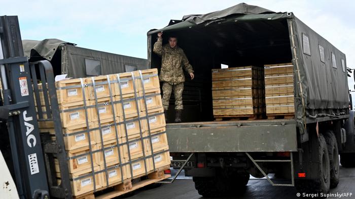 Servicemen of Ukrainian Military Forces Employees load trucks with US military aid at at Kyiv's Boryspil airport on February 9, 2022