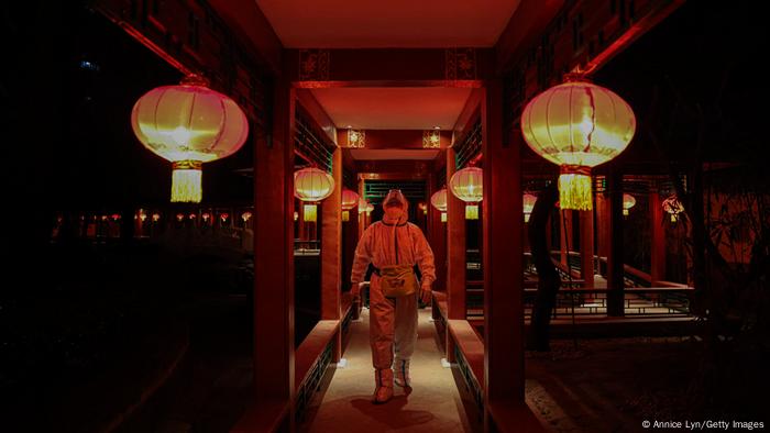 A worker in a hazmat suit works in a hotel restaurant, which is part of the closed-loop Winter Olympics Accommodation Allocation Agreement (AAA)