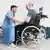 Physiotherapie für einen Mann im Rollstuhl