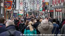 People walk a shopping street in Cologne, Germany, Wednesday, Feb. 9, 2022. New corona rules for retailers started today in the most populated province North Rhine-Westphalia. (AP Photo/Martin Meissner)